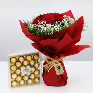 The image shows a bouquet of red roses with baby's breath wrapped in red paper. Next to it is a box of Ferrero Rocher chocolates.