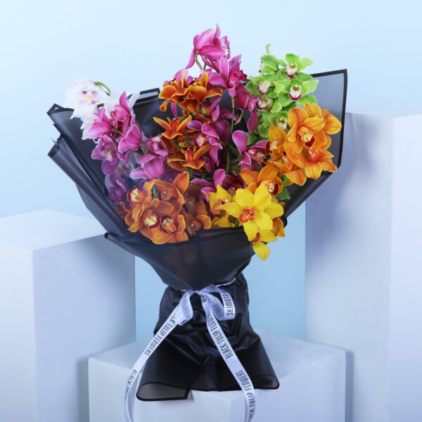 A bouquet of assorted cymbidium orchids in various colors wrapped in black paper with a ribbon