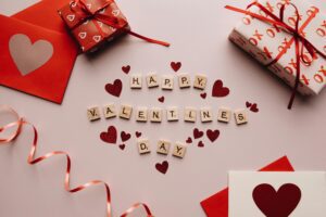 The word "HAPPY VALENTINE'S DAY" is spelled out using letter tiles surrounded by red hearts.